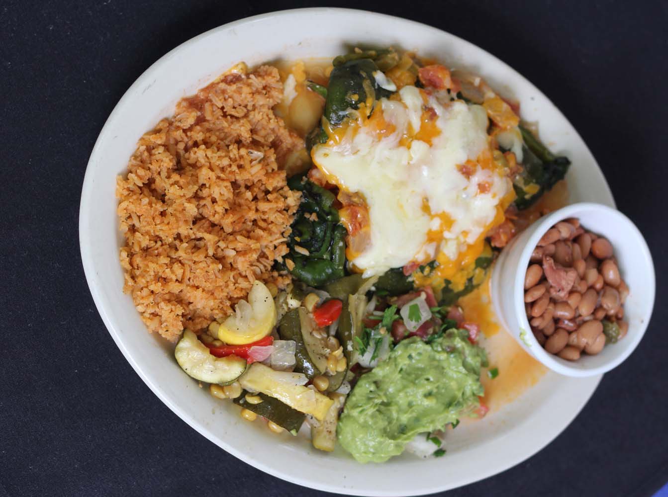 Chile relleno plate with rice, beans and guacamole