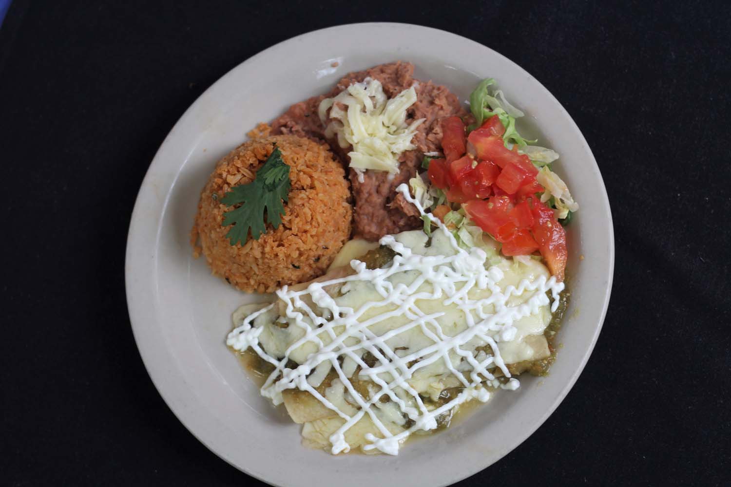 Enchiladas verdes with rice and refried beans